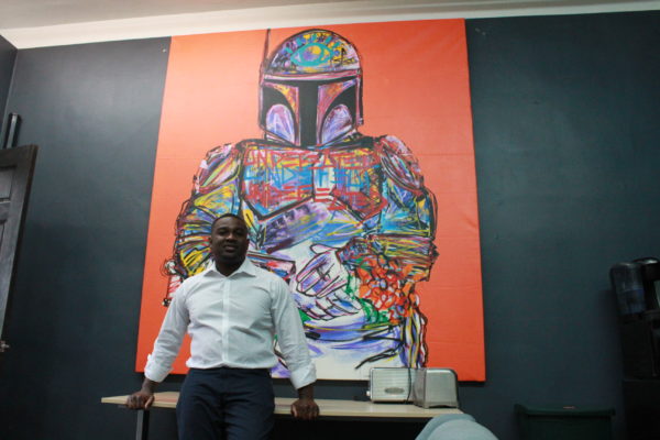 Max Dennison standing in front of a mural of Boba Fett from the movie series, Star Wars