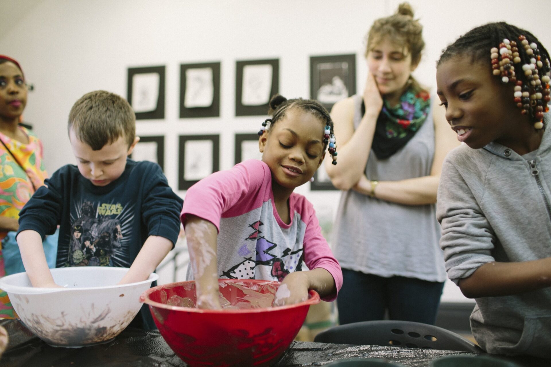 Three children participate in a clay modeling activity at Assemble.