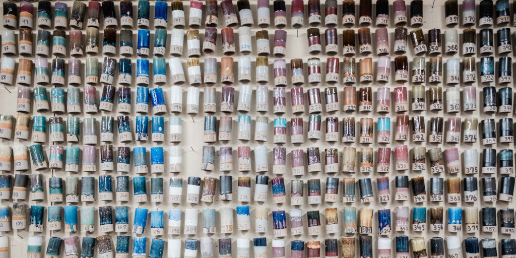 A wall of colored pigments in a ceramics studio.