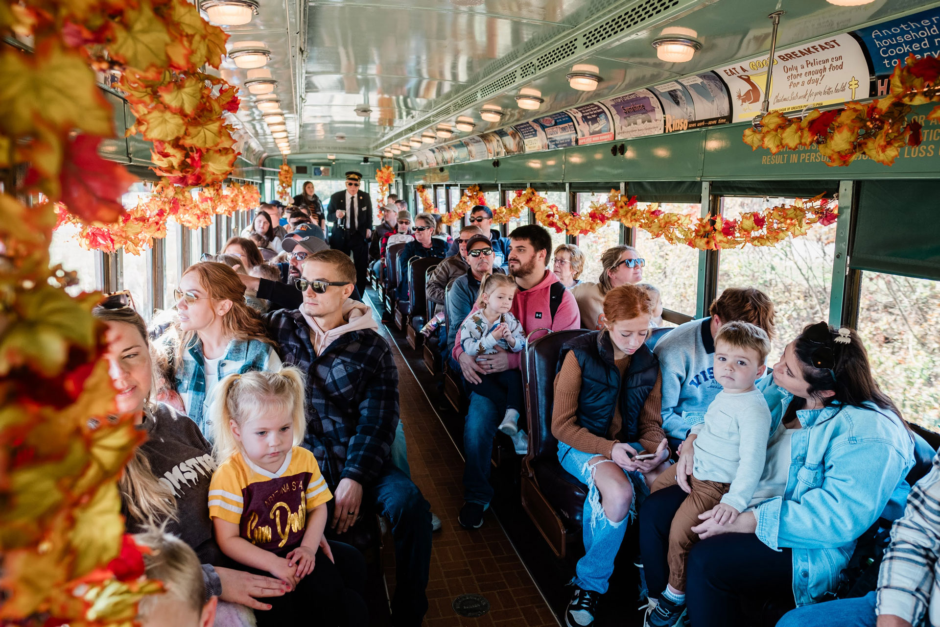 People seated inside an antique street car at the Pennsylvania Trolley Museum.