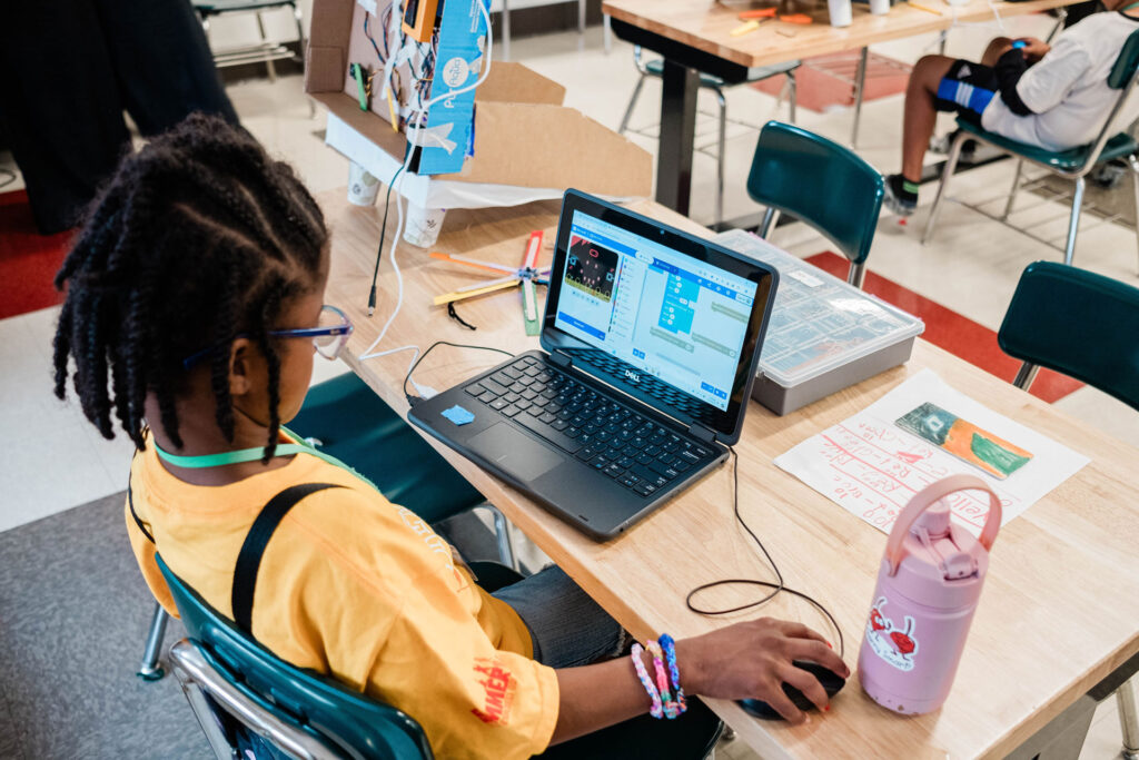 A middle school student works on a laptop.