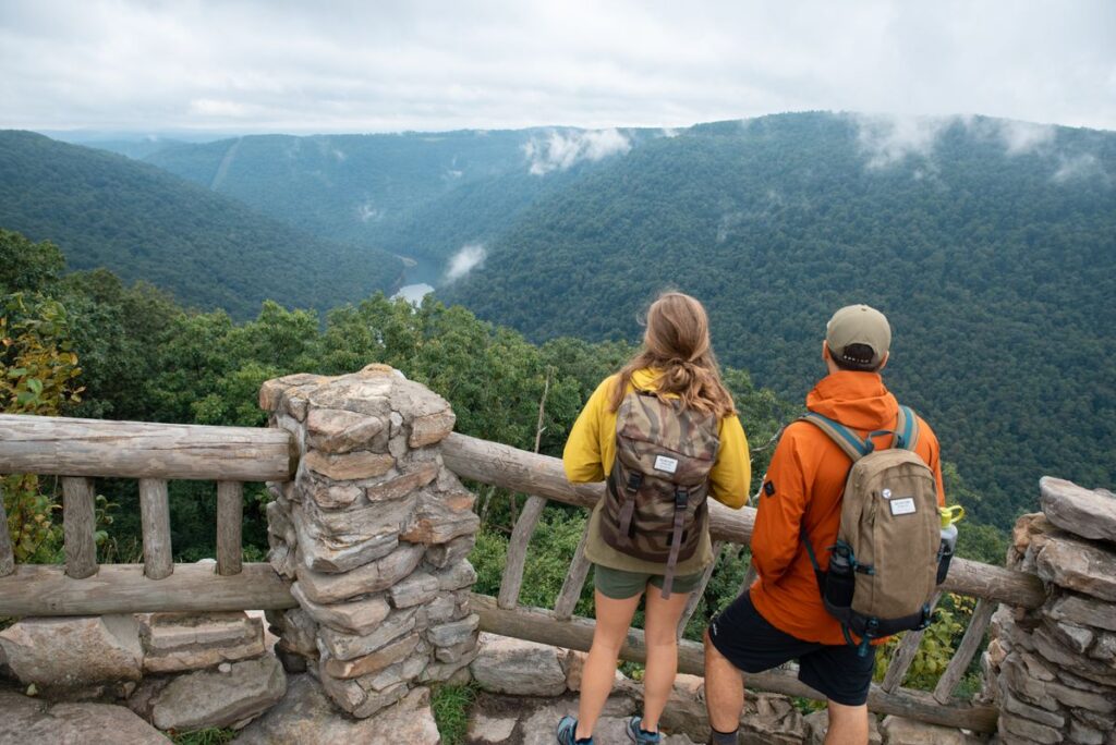 A man and a woman overlooking a mountain valley.