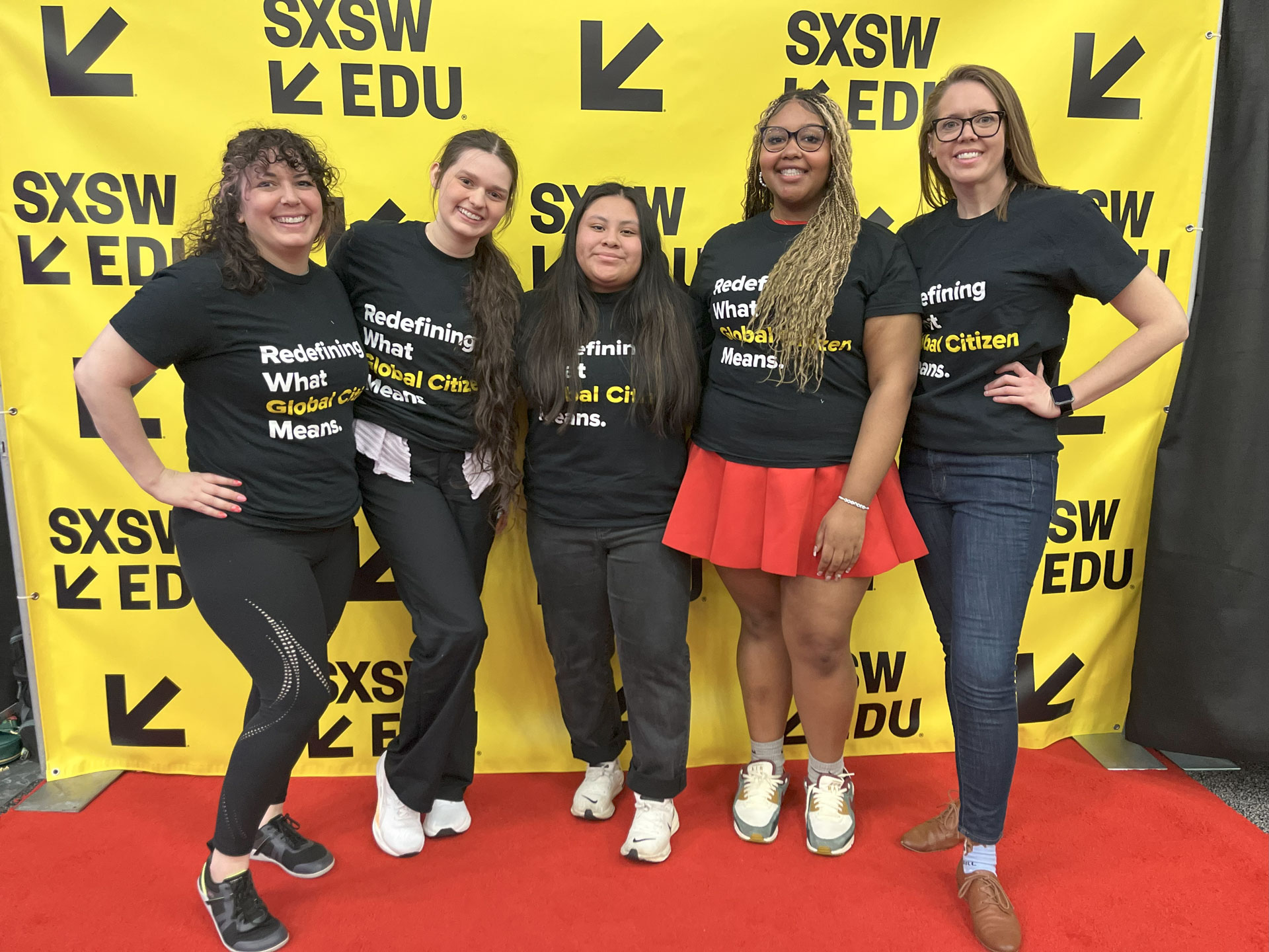 A group of five young women posing in front of a banner at SXSW EDU