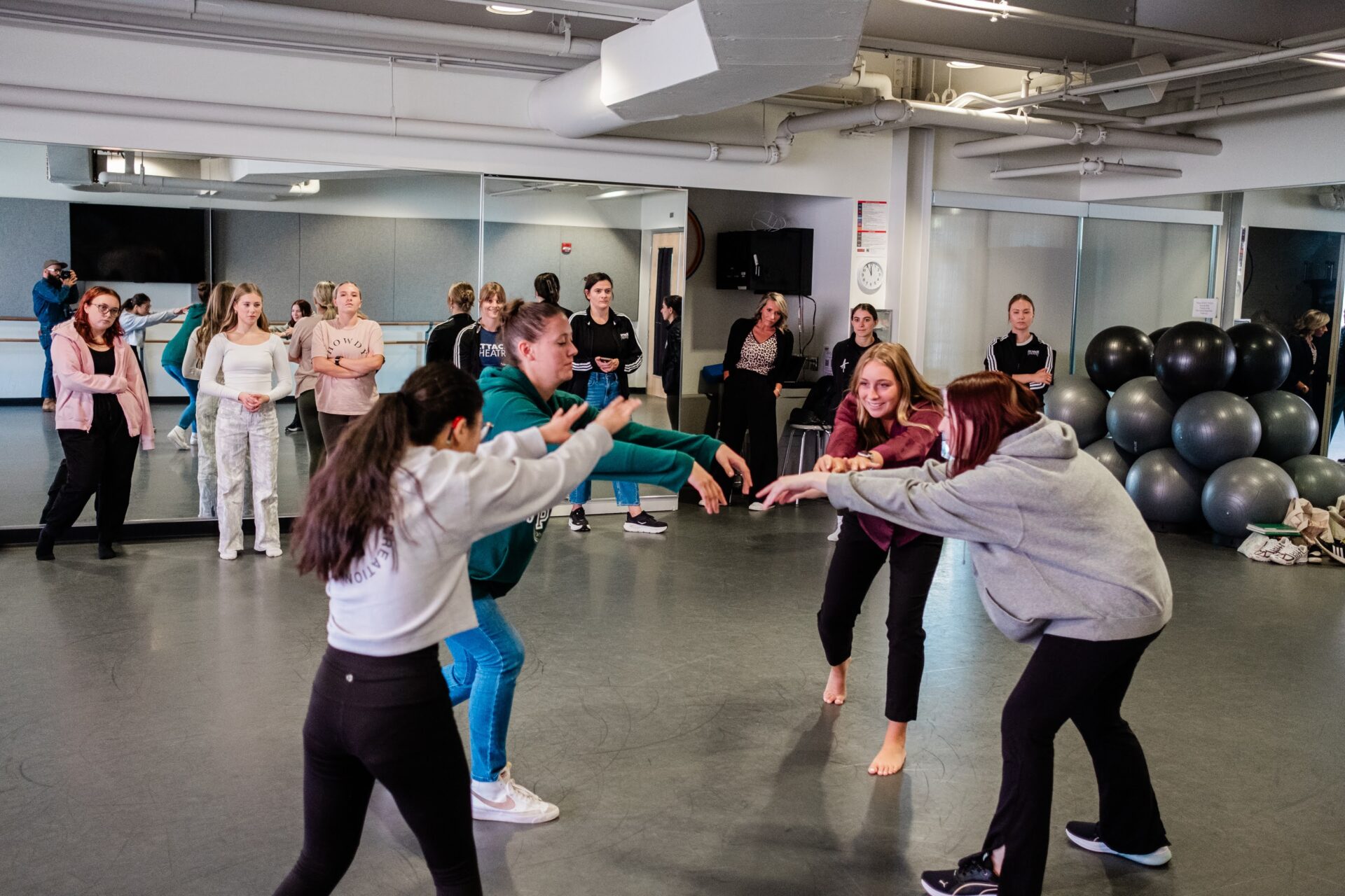 A group of women dance in a dance studio.